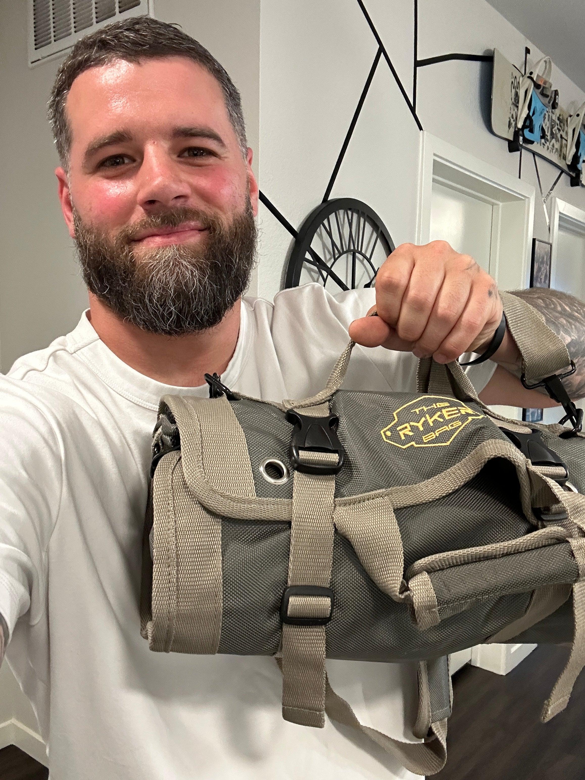 Tradesman holding The Ryker Bag roll up tool bag in workshop